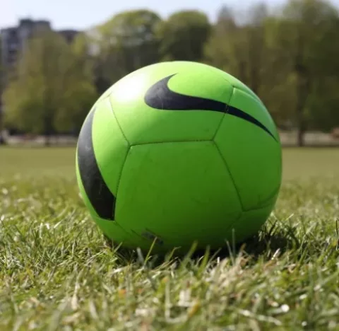 Green Nike football on grass